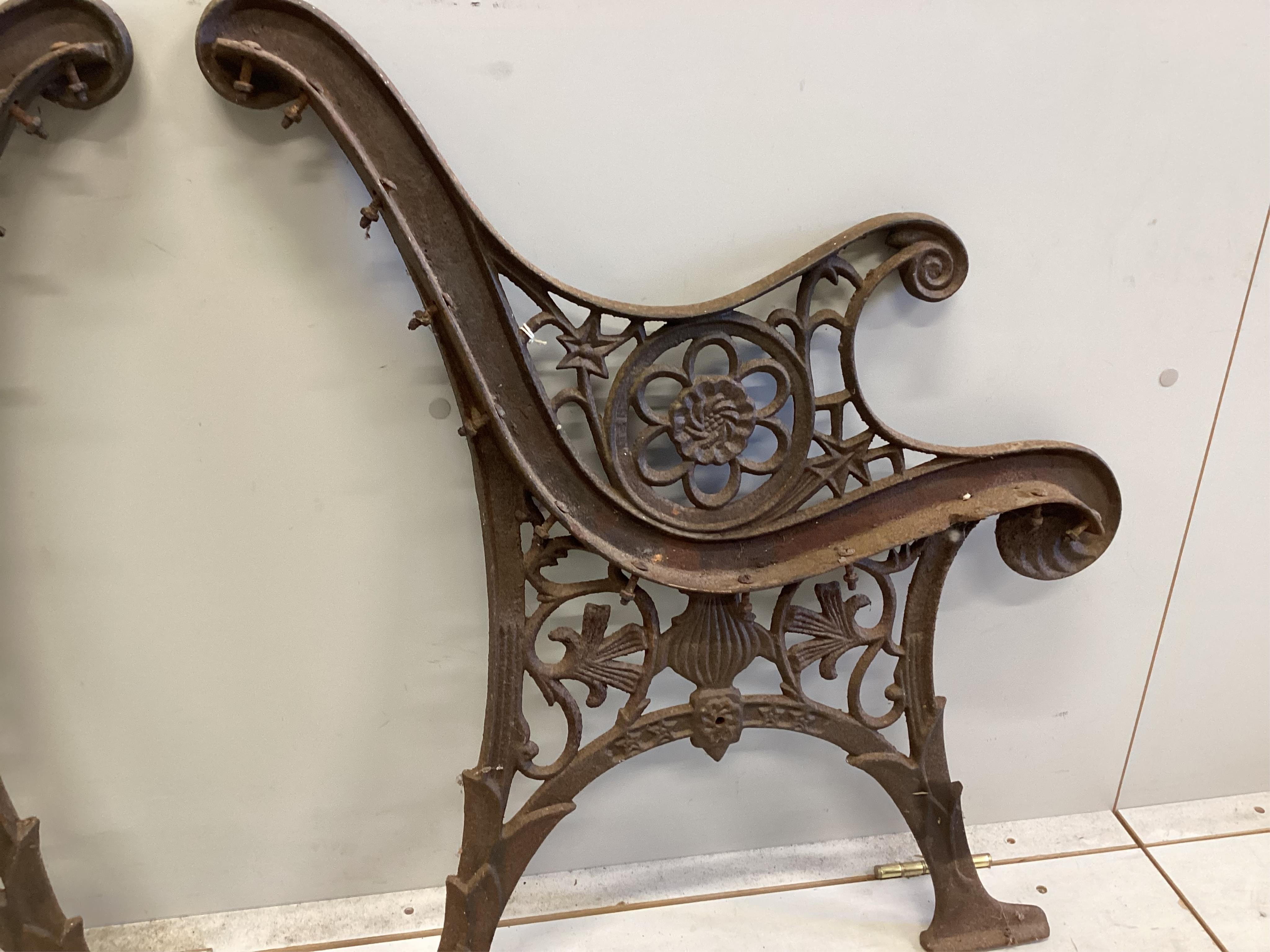 A pair of cast iron bench ends, each width 60cm, height 74cm